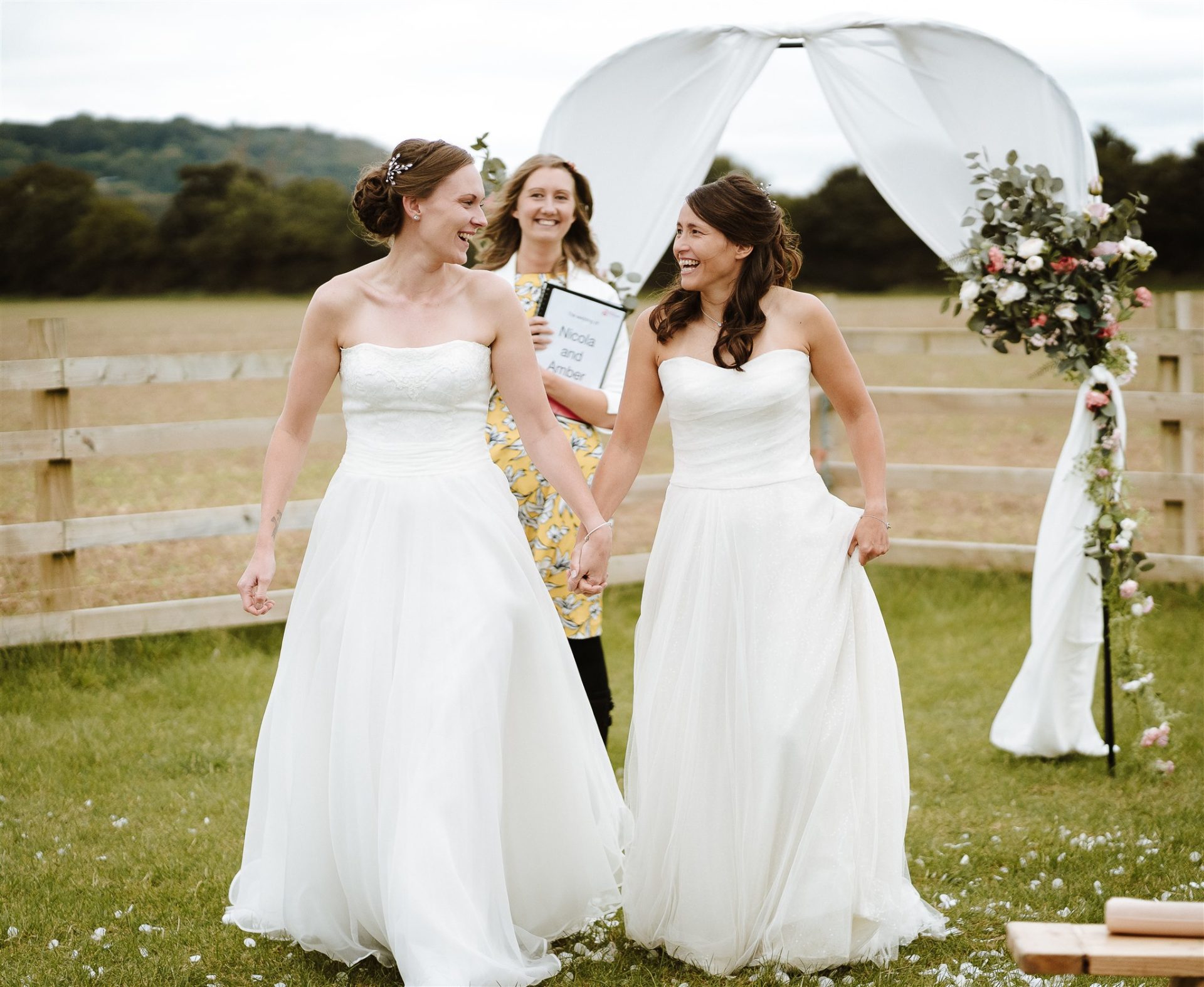 Amber and Nicola walking back up the aisle after their ceremony in Payhembury