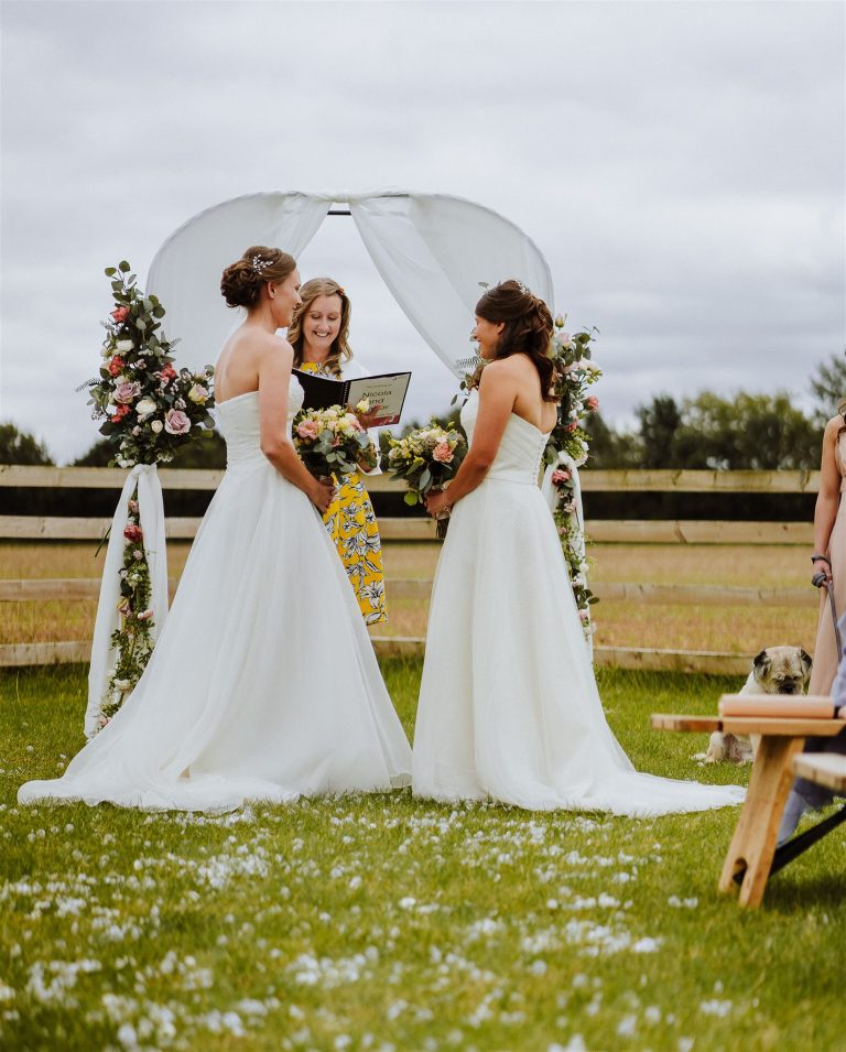 Amber and Nicola at their outdoor ceremony arch in Payhembury
