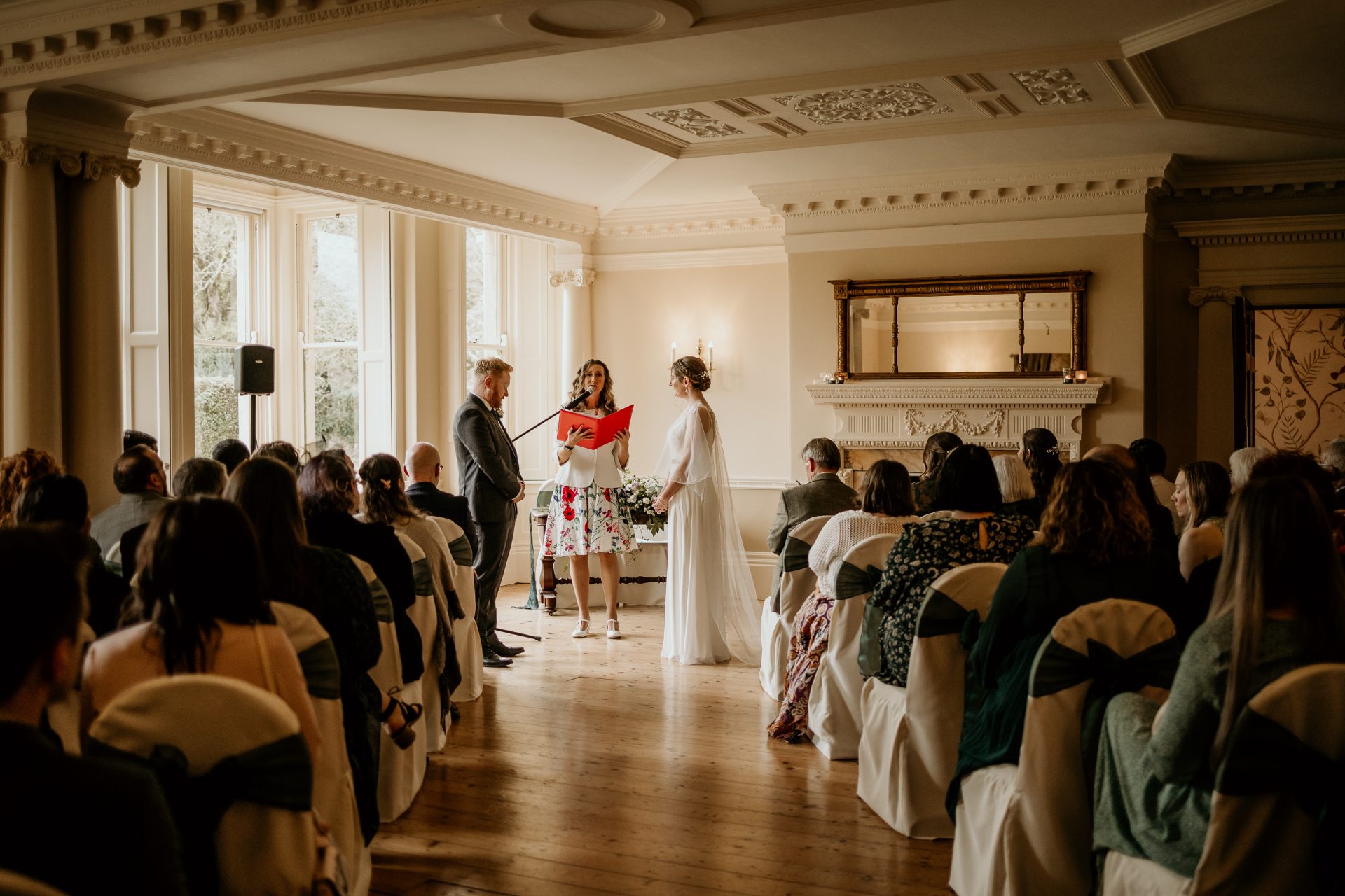 Guests watching Emily and Owen's wedding ceremony in an elegant ballroom