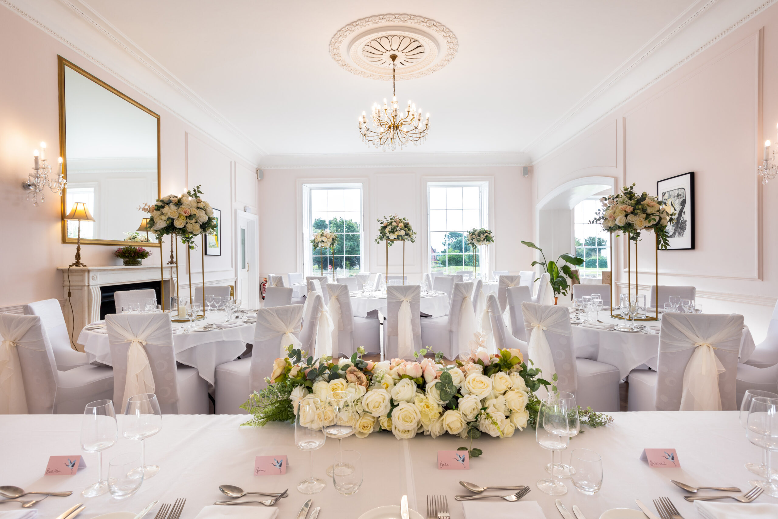 Wedding breakfast tables laid with white linen and flowers at Exeter Golf and Country Club