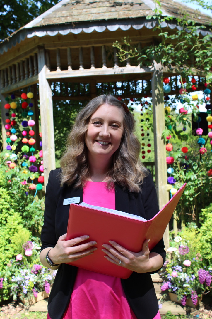 Julie Fox with her ceremony folder beside the gazebo at Netherton Hall, Farway