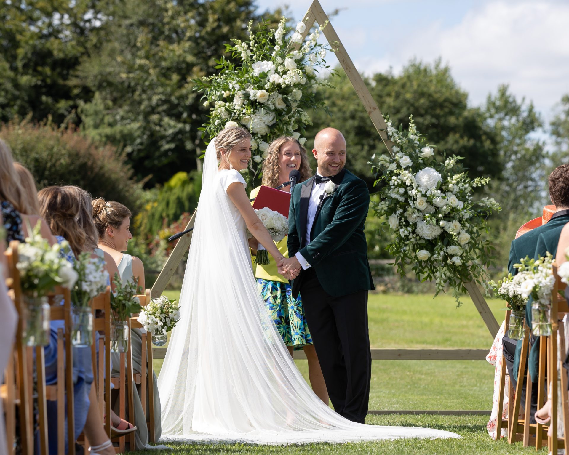 Julie Fox leading Lucy and Beau's ceremony at the floral arch in Stoodleigh