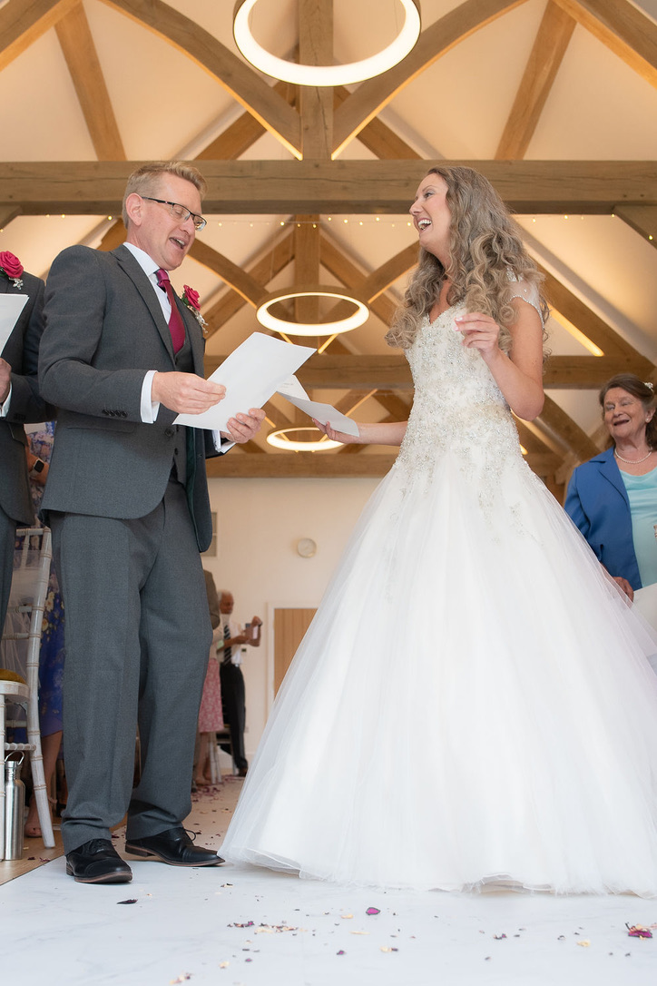 A reading during Julie Fox's wedding ceremony in the oak barn at Glebe Barn