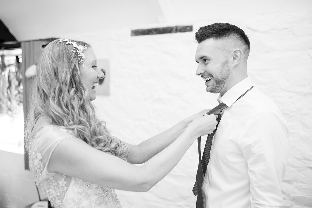 Julie Fox straightening her man of honour's tie on her wedding day at Glebe Barn