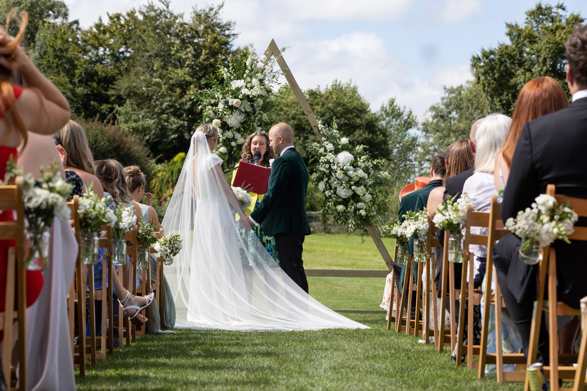 Lucy and Beau at their outdoor ceremony, with guests either side of the aisle