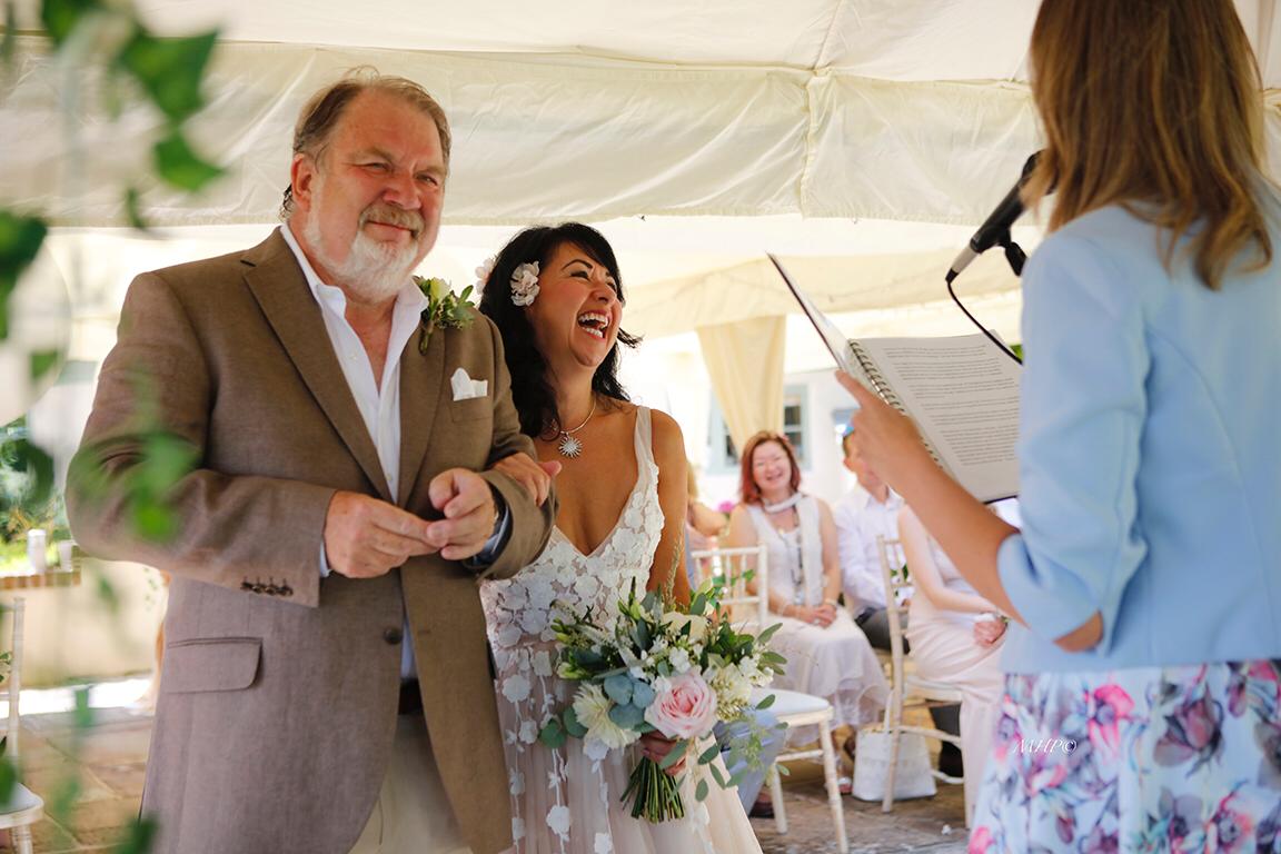 Malcolm and Deborah laughing together during their small wedding ceremony