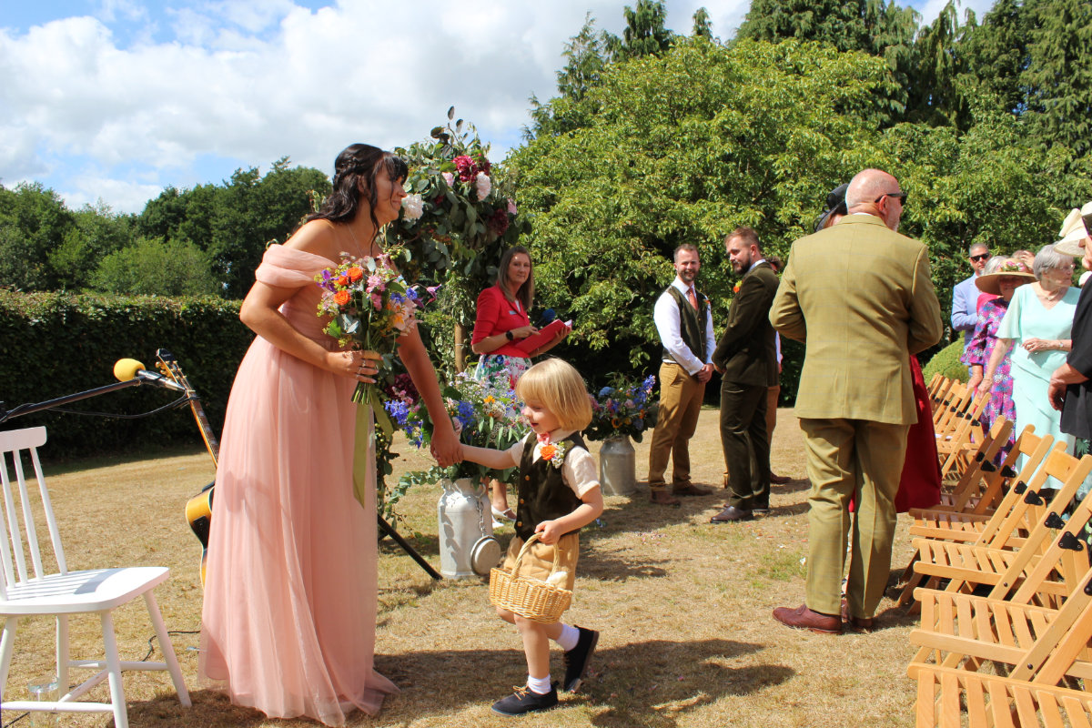 Guests and a little flower girl gathered for an outdoor wedding ceremony