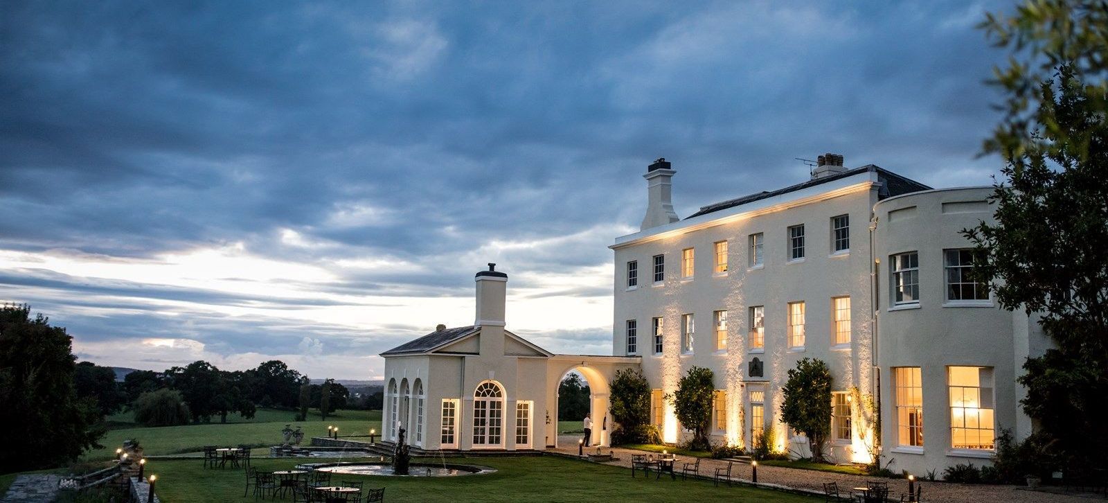 Rockbeare Manor, a Georgian country house near Exeter, lit up at dusk