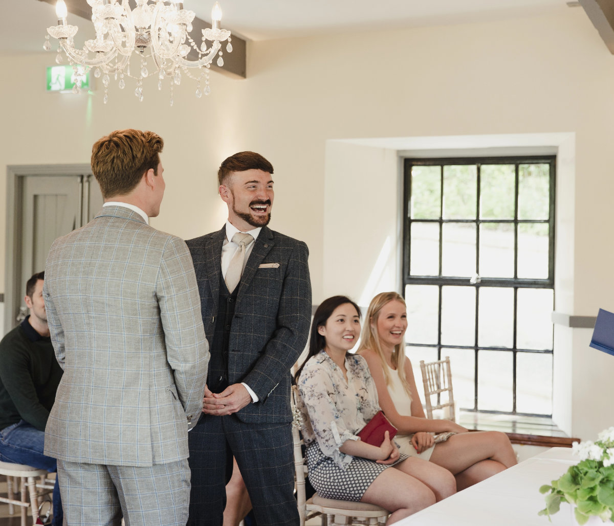 Two grooms exchanging vows in front of their guests