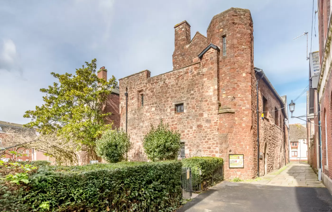The medieval red sandstone walls and garden at St Nicholas Priory in Exeter